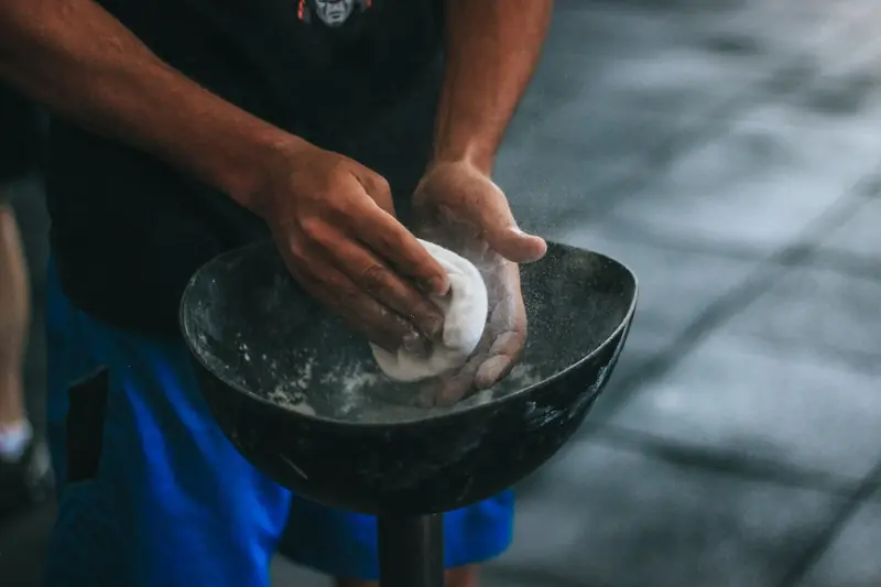 A man prepares chalk powder for climbing exercises with focus on hands in motion
